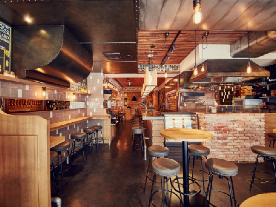 Interior with a brick counter and open kitchen at YONA YONA BEER WORKS Kanda Branch