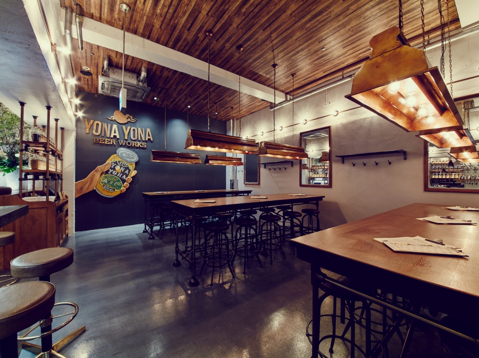 Large graphic of a hand holding YONA YONA ALE on the wall at YONA YONA BEER WORKS Kichijoji Branch
