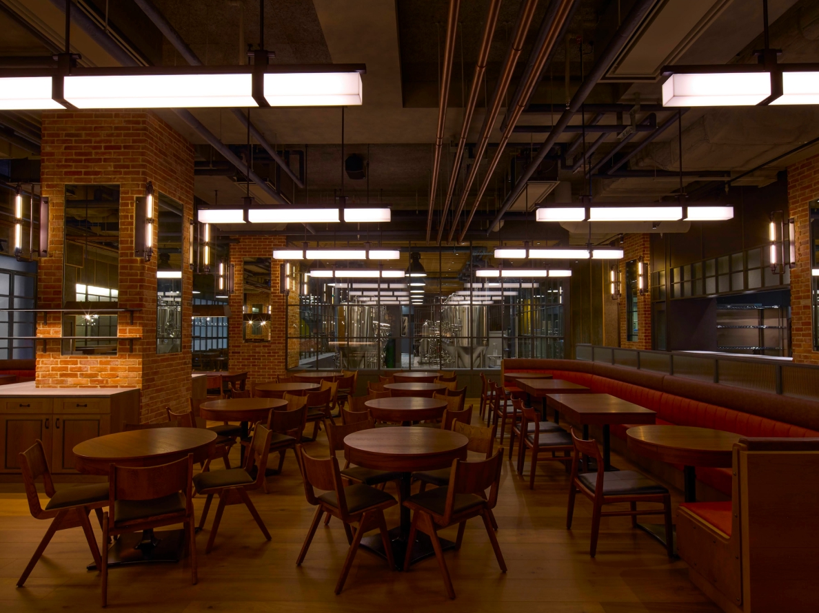 Interior of YONA YONA TOKYO BREWERY with brick pillars and indirect lighting