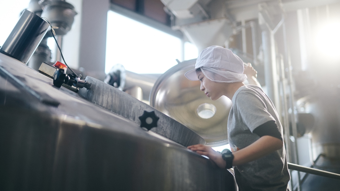 A brewer in the brewery of YOHO Brewing.