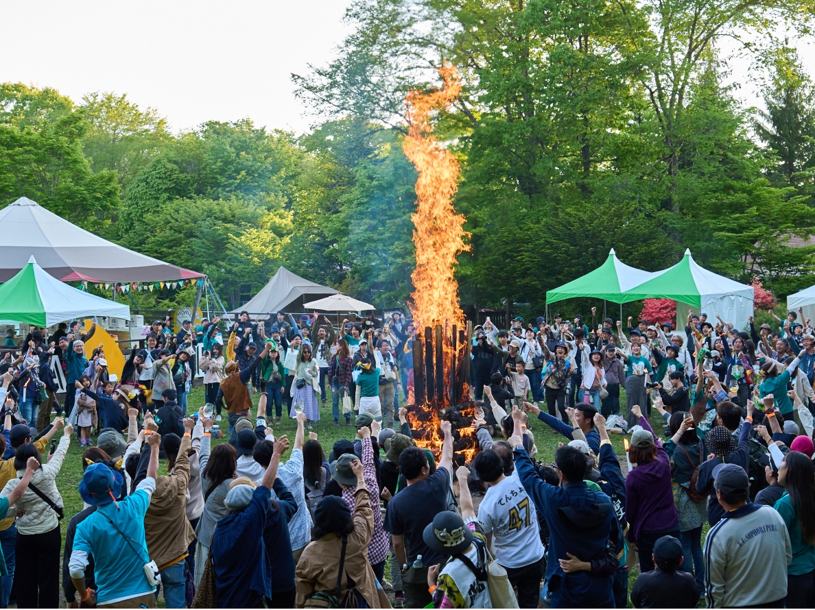 ファンがキャンプファイヤーの周りに集まっている様子